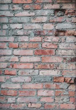 Old red brick wall, rough texture outdoors, weathered surface close-up, verti Stock Photos