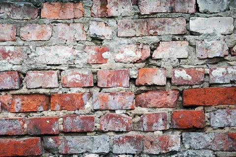 Old red brick wall texture with weathered surface and crumbling mortar layers Stock Photos