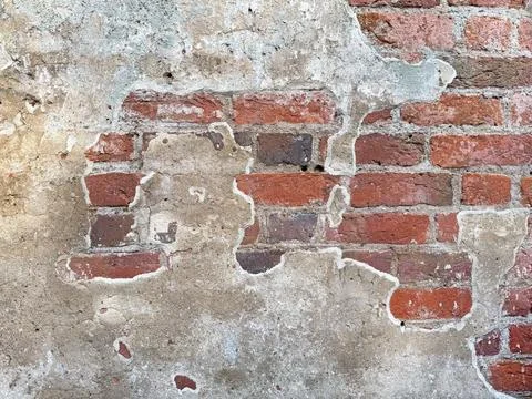 Old red brick wall texture with peeling plaster Stock Photos