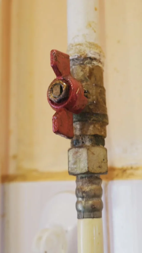 Old Red Butterfly Valve on Rusty Metal Plumbing Pipe Against Tiled Wall Видео 334129682