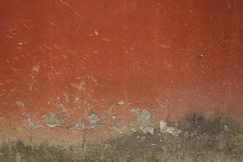 Old red concrete wall surface with black spots and damages. deep scratches on Stock-Fotos