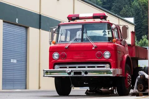 Old red dismantled fire engine parked in an industrial complex Stock Photos
