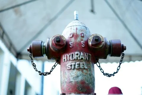 Old Red fire hydrant outside building Foto stock