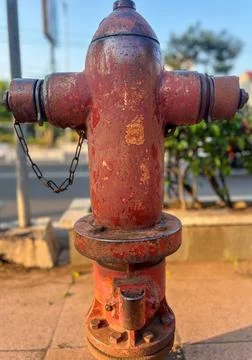 Old Red Fire Hydrant on Sidewalk with Rust and Texture Details Foto stock