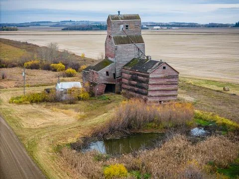 An old red grain elevator sits in a field Stock Photos
