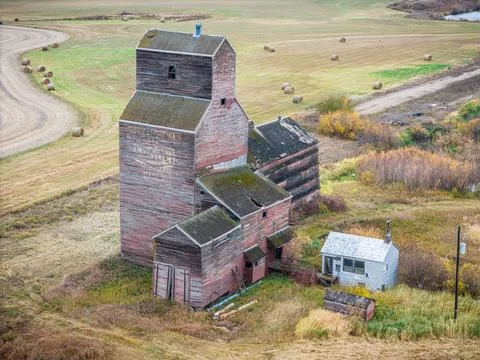 An old red grain elevator sits in a field Stock Photos