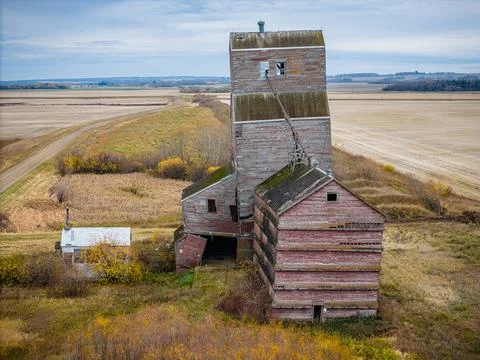 An old red grain elevator sits in a field Stock Photos