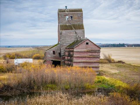 An old red grain elevator sits in a field Stock Photos