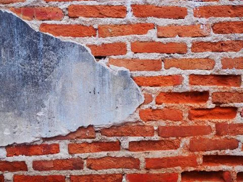 Old red long brick wall with part of grey concrete area 库存照片