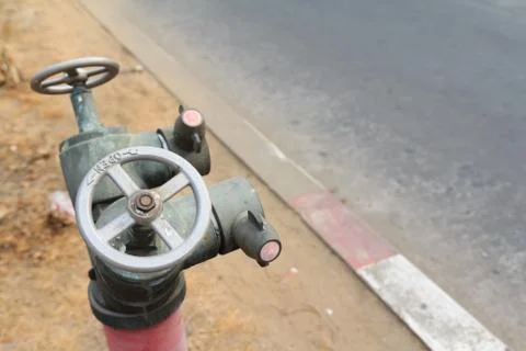 Old red metallic fire hydrant plug Stock Photos