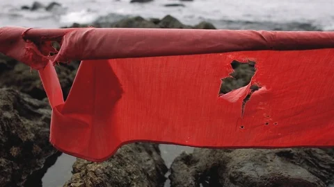 Old red ragged flag on the beach Stock Footage 106286019