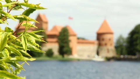 Old red stone castle. On the shore of beautiful lake. Crowd of people , tourist Stock Footage 79101715