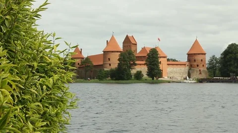 Old red stone castle. On the shore of beautiful lake. Crowd of people , tourist Stock Footage 79101953