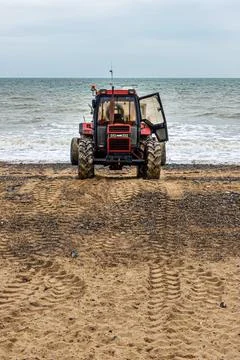 Old red tractor on a beach Stock Photos