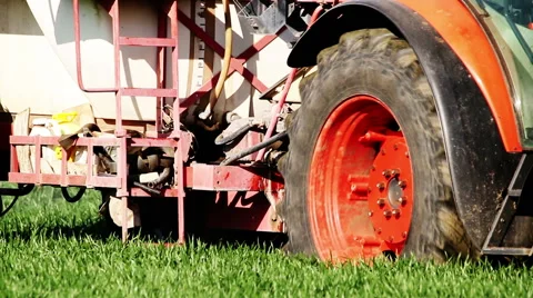 Old red Tractor spraying field, rural landscape in countryside Stock Footage 63239292