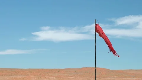 Old red windsock deep in the desert on a sandy airport runway 스톡 동영상 101661936