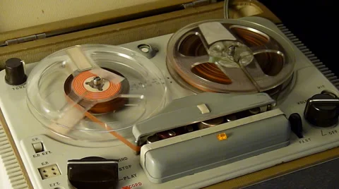 Vintage Reel to Reel tape recorder playing music close up of reel