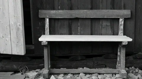 Old, repaired bench, against the wall of a wooden house,black and white Stock Footage 117112388