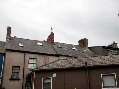 Old residential rooftops under a cloudy sky Фото