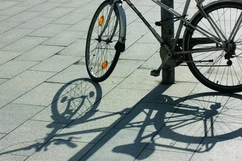 An old retro bicycle parked on sidewalk, contrasting shadow on sunny day. Wheels Stock Photos