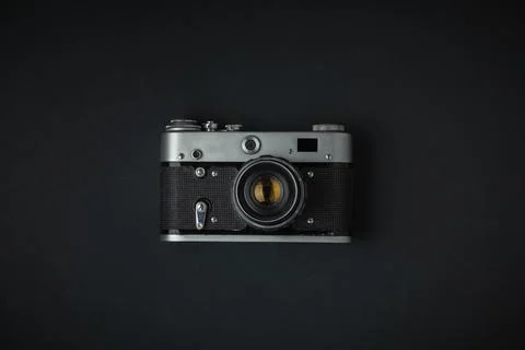 Old retro camera on the black background. Stylish background for a photo enth Stock Photos