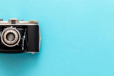 Old retro camera seen from top view in flat lay against blue pastel showing Stock-Fotos