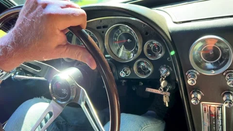 An old retro car Corvette is driving along the road a man holds his hand on the Stock Footage 202053595