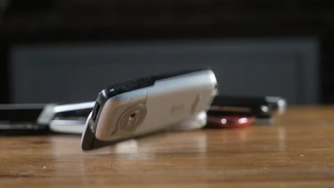 Old retro cell phones fall on the office Desk and break. 스톡 동영상 128095737