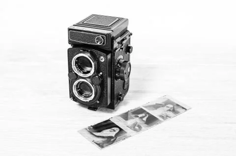 Old retro medium format camera and film negatives on white background Stock Photos