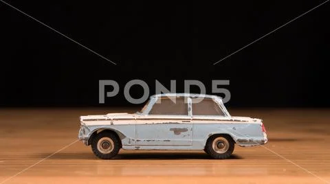 Old retro metal toy car on wooden table and black background Stock Photos