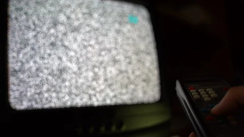 Old retro remote control in male's hand, man changing channels on vintage TV in Vídeos de archivo 129372854