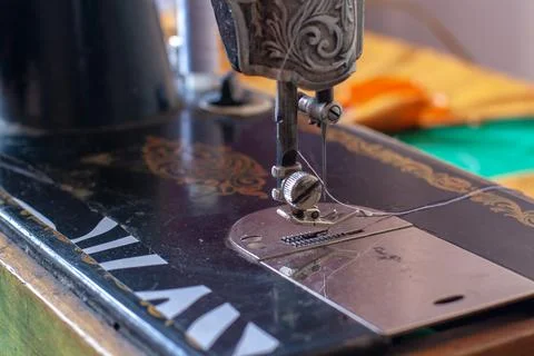 Old retro sewing machine with a needle and inserted white thread. Shallow dep Stock Photos