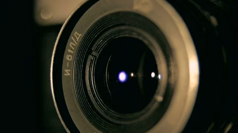 Old retro style camera lens in the dark studio rounding light indoors Video stock 64854773