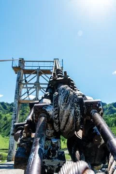 Old river bridge with a tower under the sunbeams. Metallic cable Stock Photos