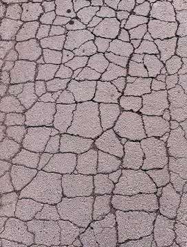 Old road background - surface of gray cracked asphalt close up Stock Photos