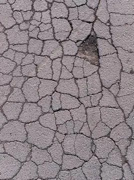 Old road background - surface of gray cracked asphalt close up Stock Photos
