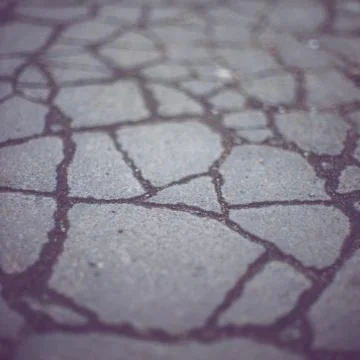 Old road surface made of old asphalt with cracks. Stock Photos