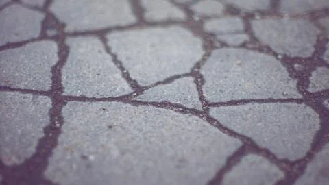 Old road surface made of old asphalt with cracks. Stock Photos