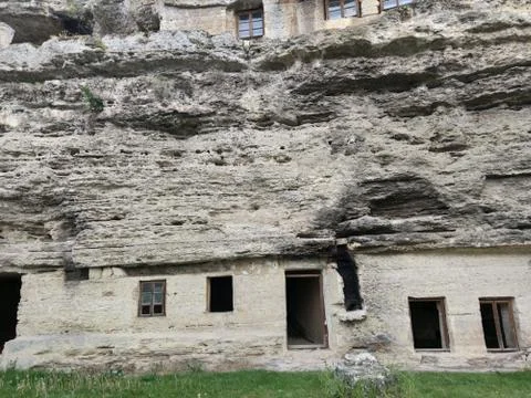 Old rock monastery. Empty window openings. Second floor with glasses. Green Stock Photos