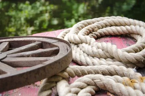 Old rolled ropes and a rusty wheel Stock Photos