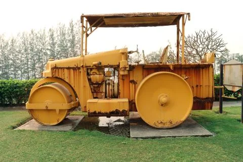 Old roller compactor machine with yellow color on green garden Stock Photos