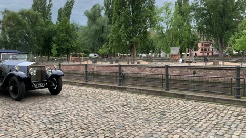 Old Rolls Royce Phantom convertible car passes on Strasbourg cobble stone street Stock Footage 197389404