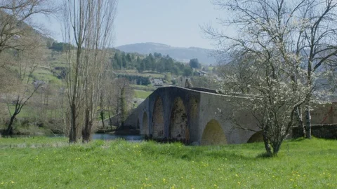 Old roman bridge over a river. Nice countryside with mountains during spring Video stock 128743313
