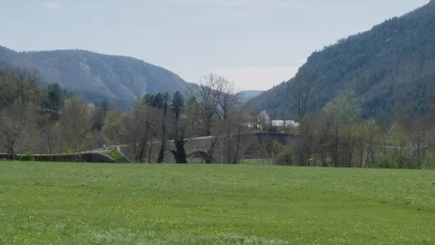 Old roman bridge over a river. Nice countryside with mountains during spring (2) Stock Footage 128743495