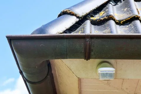 Old roof gutter system needing cleaning and repair Stock Photos