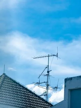 Old rooftop television antenna with multiple elements against clear blue sk.. 写真素材