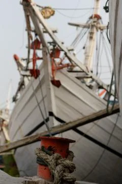 Old ropes hold a ship next to the dock in Jakarta Indonesia Stock Photos