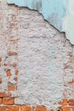 Old rough exposed red brick wall with plaster and paint falling off Фото