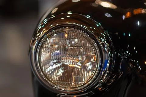 Old round headlight close up view, front light details black retro car Stock Photos