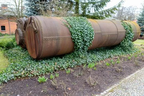 Old round rusty liquid containers. Metal barrels in a distillery. Stock Photos